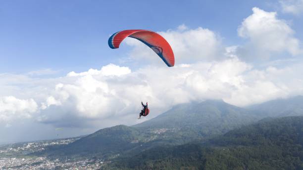 istock Paraglider Pilot flying high in blue sky and mountain panoramic 1535582706