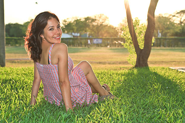 Beautiful girl smiling seated on the grass