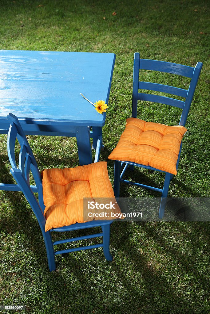 Two garden chairs Two blue garden chars and the table with a sunflower on it Blue Stock Photo