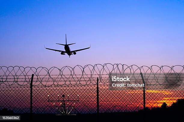 Jet Airplane In The Distance Landing At Sunset Behind Fence Stock Photo - Download Image Now
