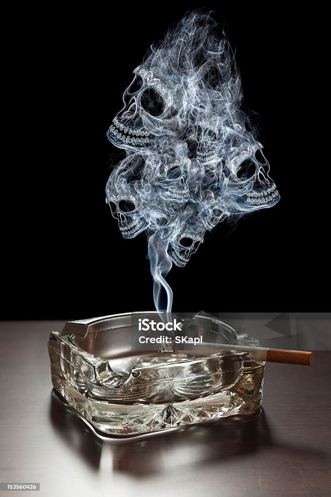 Danger of smoking Many smoke skulls rising from a cigarette. Abstract Stock Photo