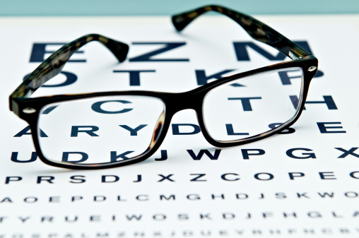Black eyeglasses on visual test chart isolated on white