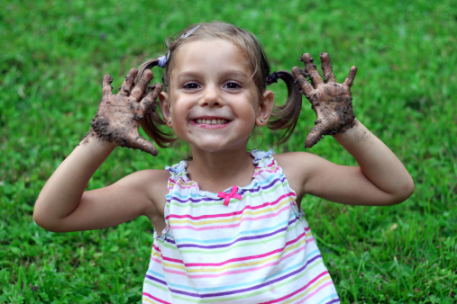 little girl with muddy hands