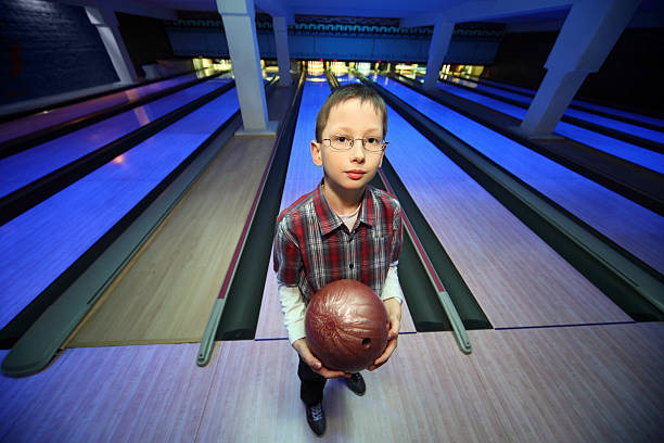 istock Boy stands with ball for bowling and looks ahead 153564823