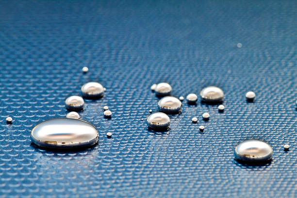 Droplets of mercury on a textural blue surface Shiny Mercury drops on a blue background mercury metal stock pictures, royalty-free photos & images