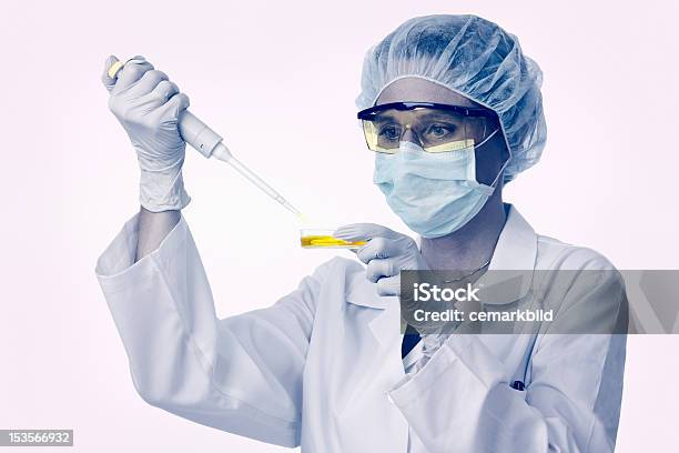 Photo libre de droit de Technicien De Laboratoire Femelle Travaillant Avec Pipette Et Jaune Liquide banque d'images et plus d'images libres de droit de Adulte