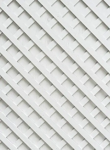 Shot of white garden lattice against a white wall.