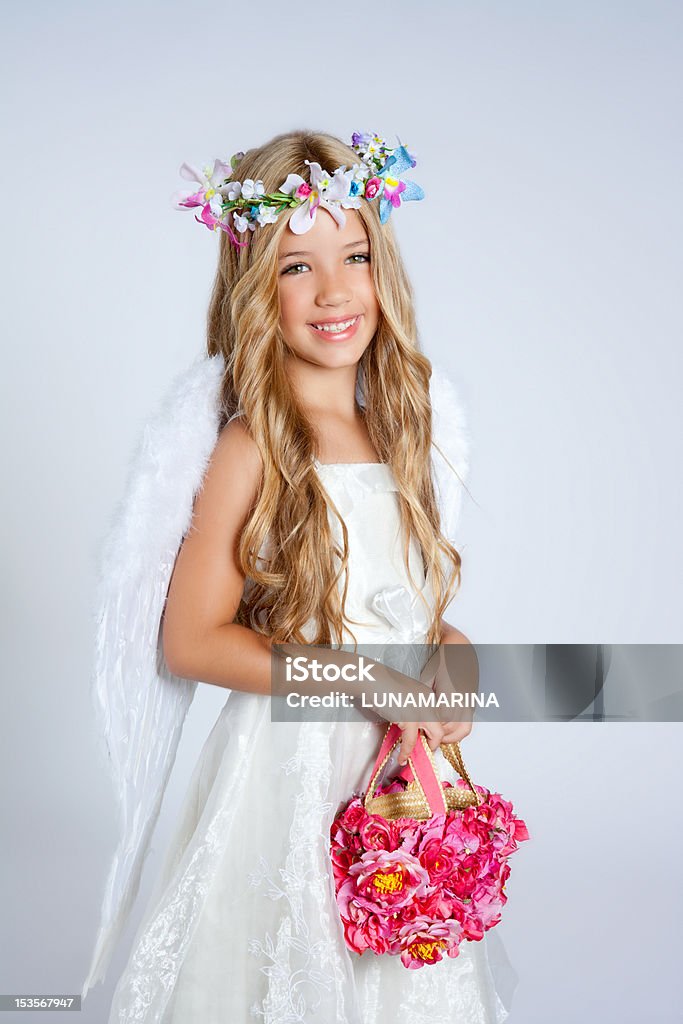 Ángel niños girl holding flowers bolsa con alas - Foto de stock de 6-7 años libre de derechos
