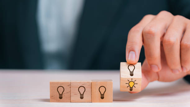 istock Leader choosing the best new idea with light bulb icon on wooden blocks. Explore creative design, solutions, strategy reviews. Inspiring innovation and teamwork. 1535691711