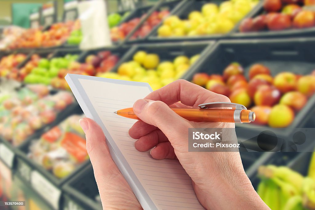 Ręka z pióro pisania listy zakupów w supermarkecie owoce - Zbiór zdjęć royalty-free (Lista)