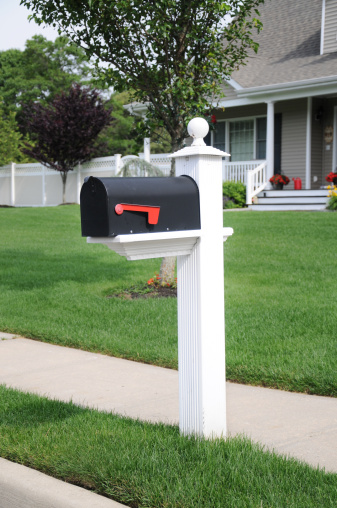 Black mailbox along sidewalk in surburban residential area