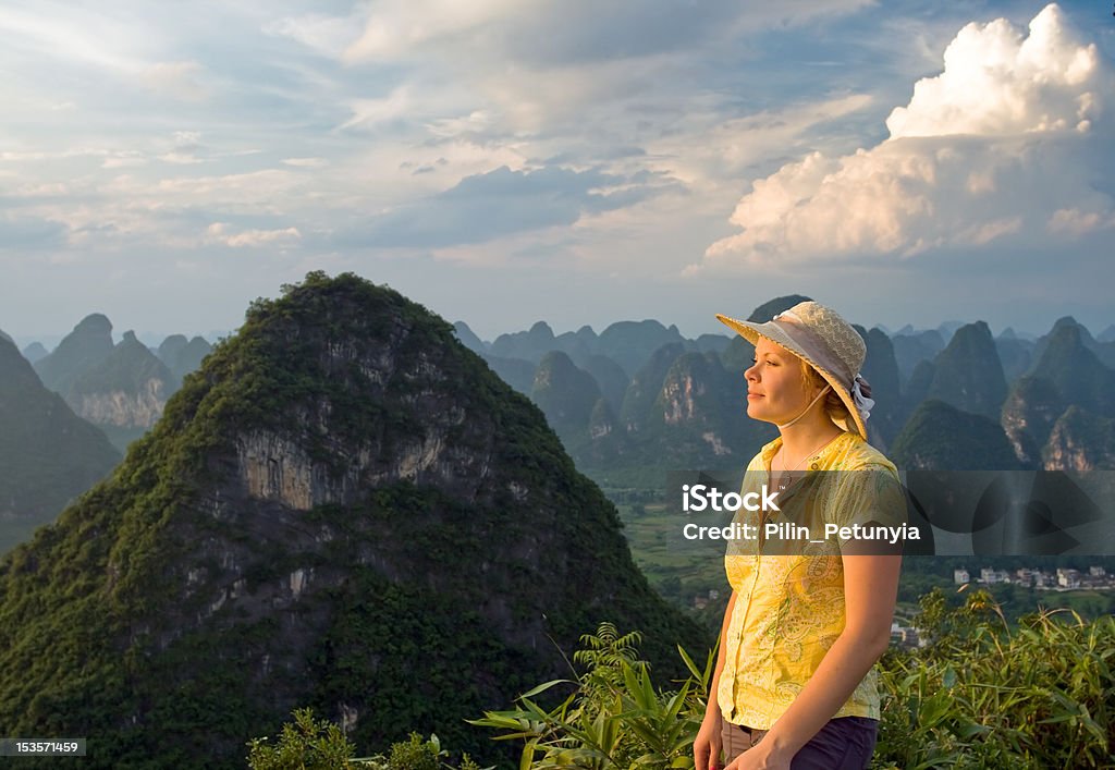 Felice giovane donna in cima alla montagna - Foto stock royalty-free di Abbigliamento