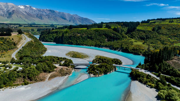 a vista aéreacom ponte estrada lagoa do rio vale e água azul rio e fundo da montanha - new zealand forest landscape mountain - fotografias e filmes do acervo