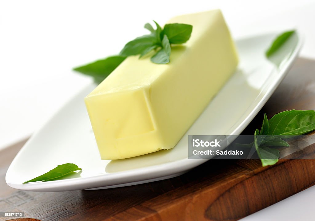 butter Fresh Butter stick on a white dish with basil leaves,close up Basil Stock Photo