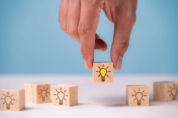 istock Leader choosing the best new idea with light bulb icon on wooden blocks. Explore creative design, solutions, strategy reviews. Inspiring innovation and teamwork. 1535723929