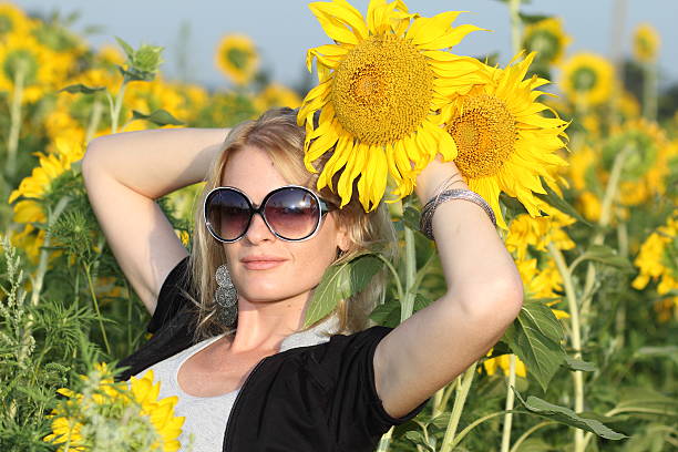 Beauty woman and sunflowers on field stock photo