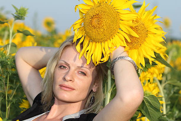 Beauty woman and sunflowers on field stock photo