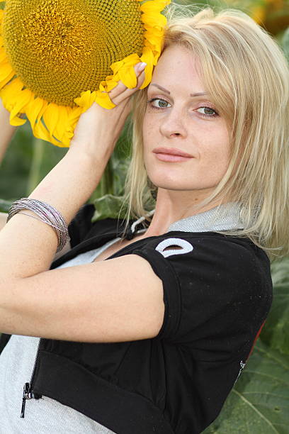 Beauty woman and sunflowers on field stock photo