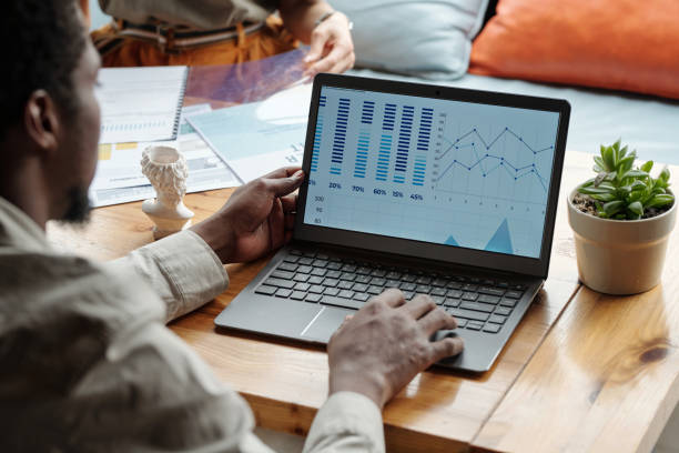 istock Focus on screen of laptop with graphic financial data on workplace 1535733891