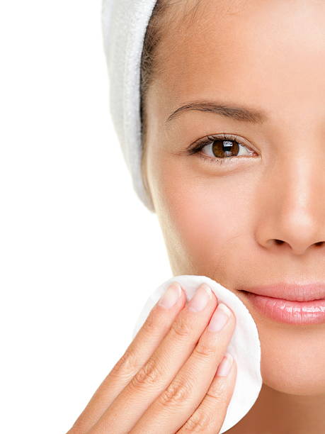 skin care woman removing makeup skin care woman removing face makeup with cotton swab pad - skin care concept. Facial closeup of pretty beautiful mixed race Chinese Asian / Caucasian female model with perfect skin. Girl isolated on white background. Similar asian eyebrows stock pictures, royalty-free photos & images