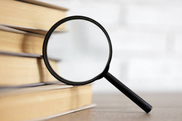 istock education and research concept - stack of books and magnifying glass on the table in library 1535740272