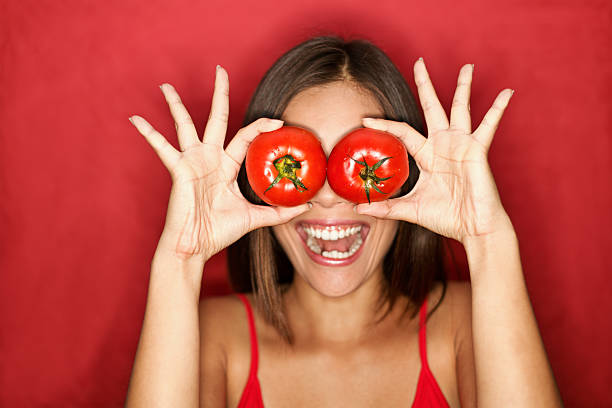 トマトの女性 - women eating fruit food ストックフォトと画像