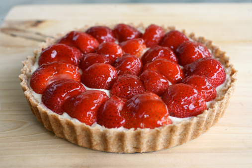 Close-up of a homemade Strawberry Tart with jam glazing against a wood background taken by a Canon 5D.
