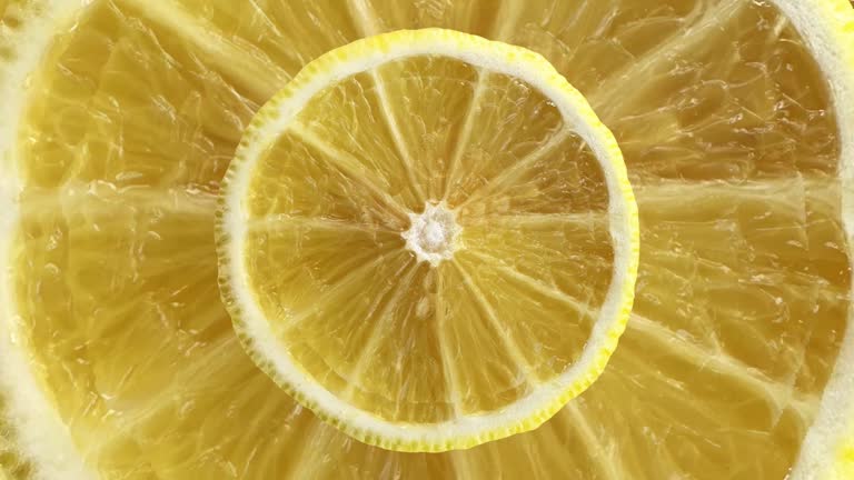 Timelapse Seamless Looping Motion of Textures of a Lemon Slice's Surface - Stock Video. Witness the graceful movement of the lemon slice as it undergoes a captivating transformation, revealing intricate details and vibrant colors in every frame.