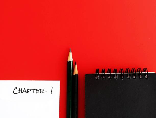 istock Notebook and pencils on copy space red background with text typed CHAPTER 1, concept of start writing books - novel fiction non-fiction, being first time writer or writers block 1535780503