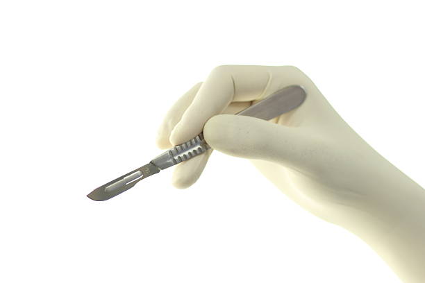 istock A latex-gloved hand holding a surgical scalpel 153578118
