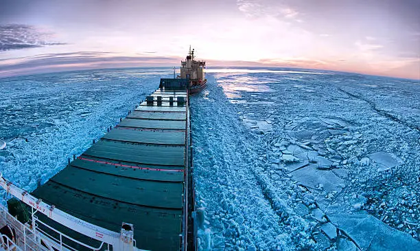 Photo of Icebreaker towing cargo ship through thick ice-field