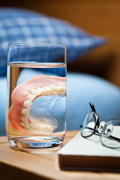 denture in einem glas wasser. - senior women grandmother glasses senior adult stock-fotos und bilder