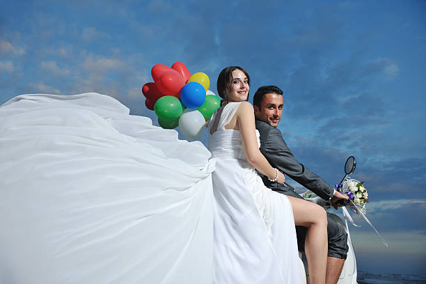 istock Just married couple riding white scooter with balloons 153584728