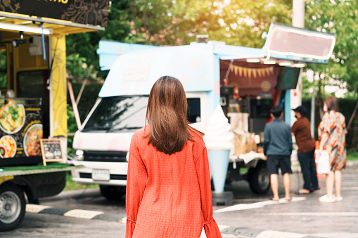 woman traveler visiting in Food Truck Market, Tourist with bag sightseeing in Weekend Market street