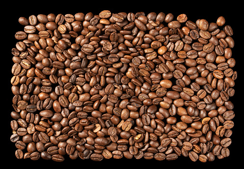 Pattern of roasted Arabica coffee beans, contrasting black background.