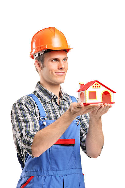 istock Male construction worker wearing helmet and holding a model house 153588829