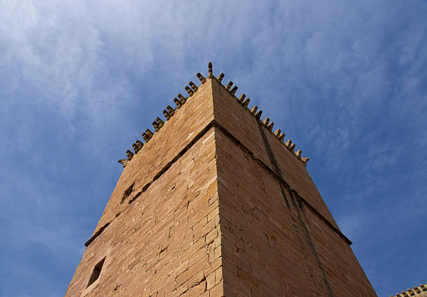 Top image of a tower silhouetted against the blue sky