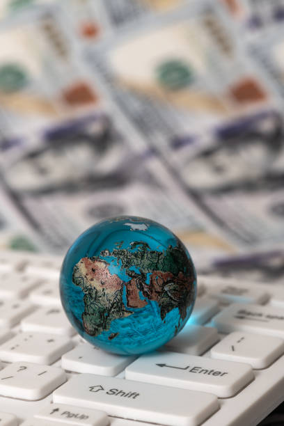 istock Glass globe on a computer keyboard against the background of 100 US dollar bills 1535901946