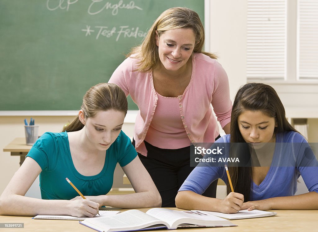 Enseignant aidant les étudiants bureau - Photo de Adolescence libre de droits