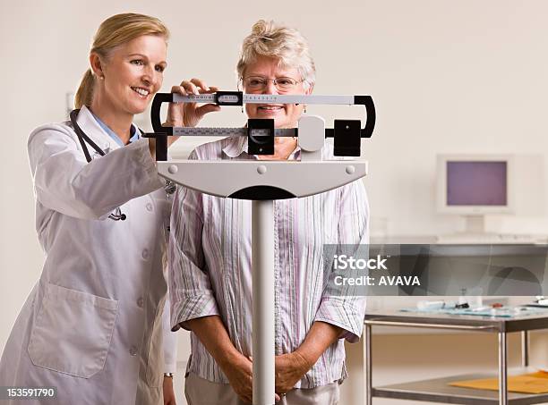 Doctor Weighing Senior Woman Stock Photo - Download Image Now - Weight Scale, Doctor, Scale