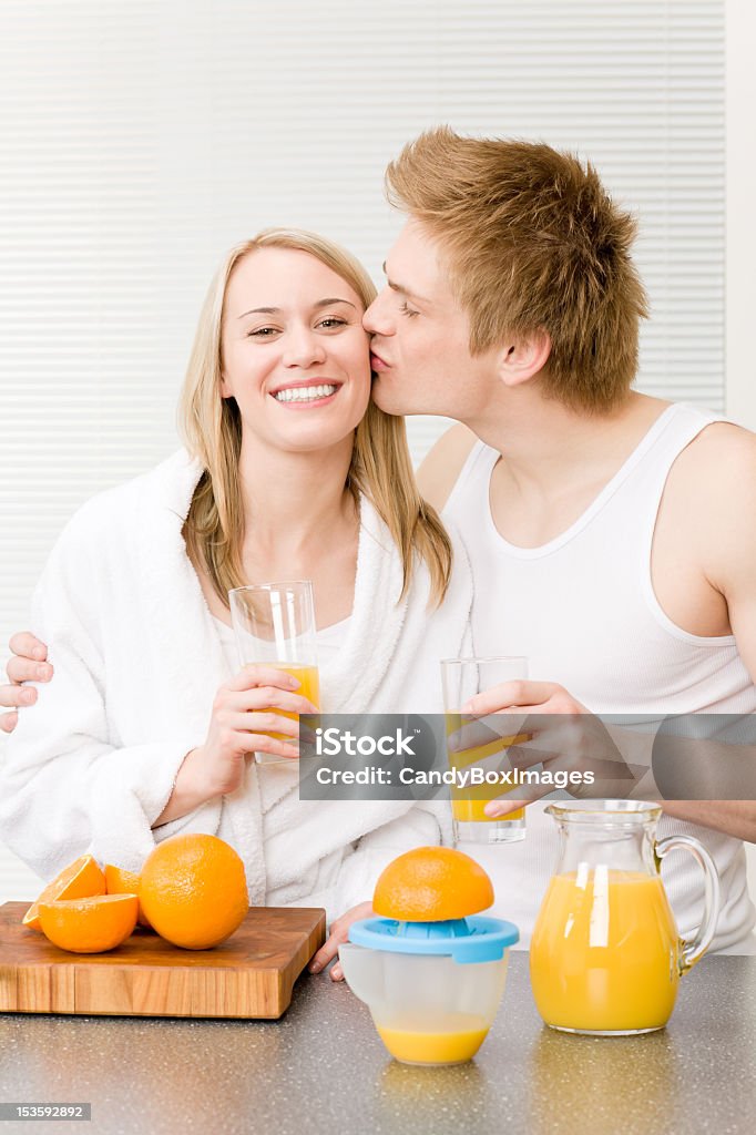 Desayuno beso pareja Disfrute de jugo de naranja - Foto de stock de Adulto libre de derechos