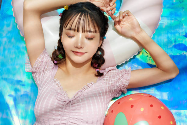 молодая азиатка отдыхает в купальнике - swimwear people fashion model leisure activity стоковые фото и изображения