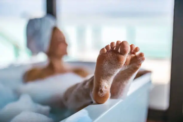 Close up of unrecognizable woman relaxing during her bubble bath in a bathroom.