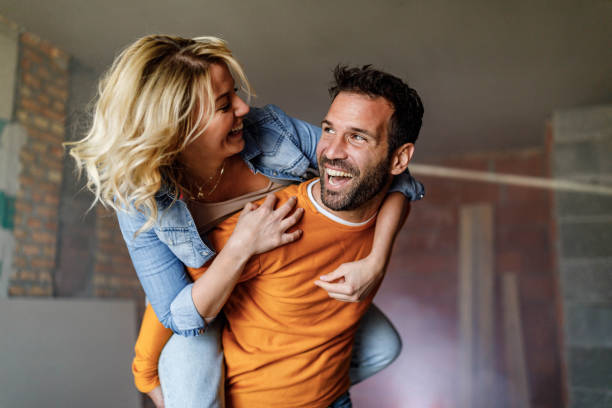 Carefree couple having fun while piggybacking at construction site.