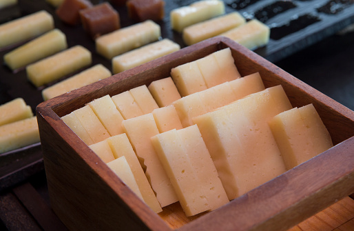 Strips of sheep cheese displayed on wooden box. Closeup