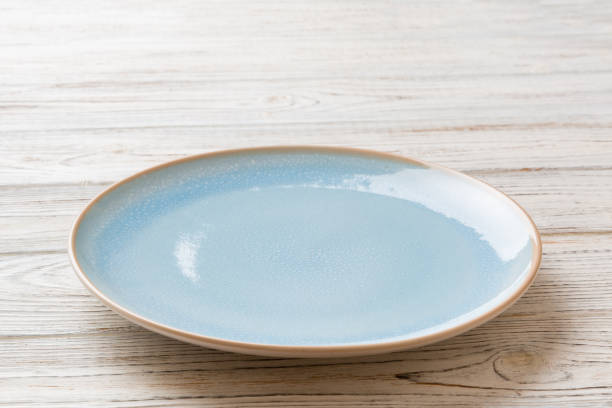 istock Perspective view of empty blue plate on wooden background. Empty space for your design 1536068373