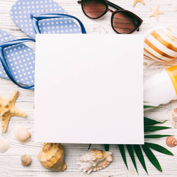 istock Summer time concept with blank greeting card and blank white paper on colored background. Seashells from ocean shore in the shape of frame separated with space for text top view 1536068788