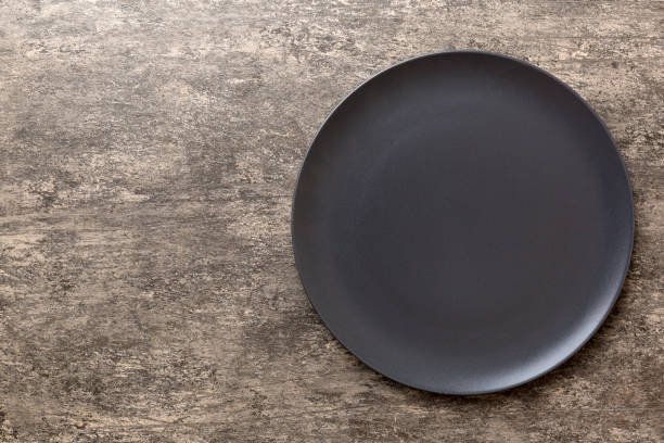 istock Top view of black plate on cement background. Empty space for your design 1536068795