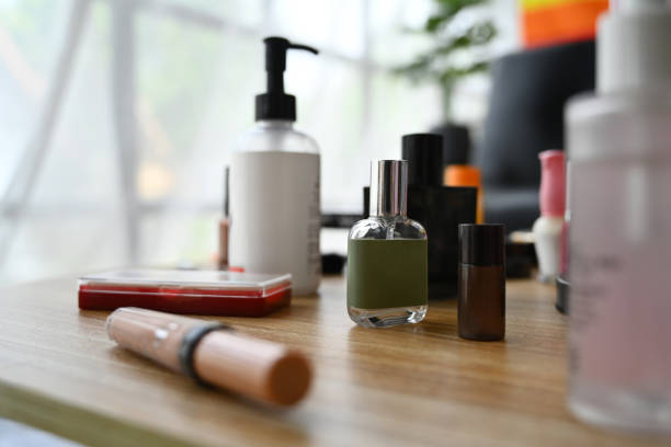 化粧台の上のスキンケア製品、ローションボトル、丸い鏡、化粧ブラシの接写。