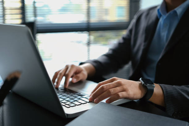istock Professional businessman Hans typing on laptop, doing online data market analysis at office desk. 1536089526